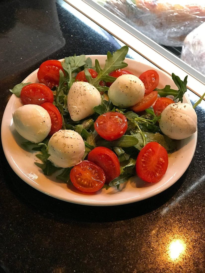 Before — Caprese salad with tomatoes and mozzarella — phone photo relit to studio quality with PlateRefresh