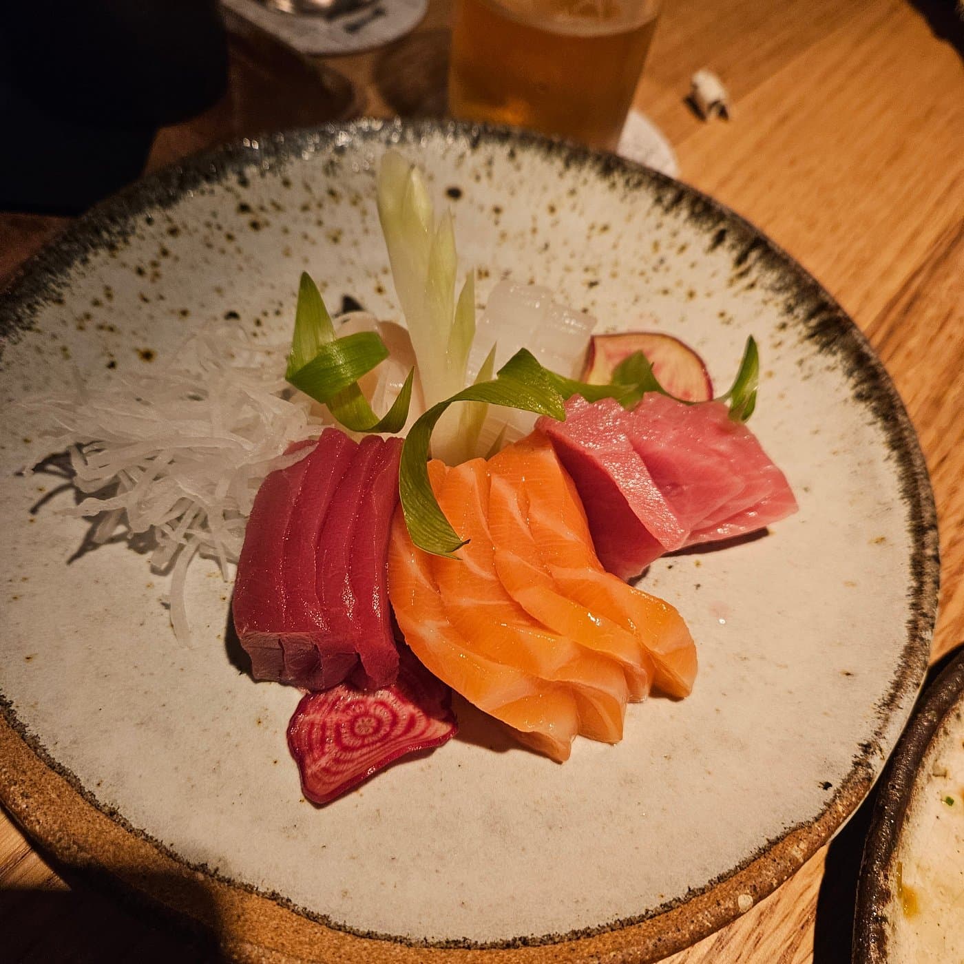 Before — Salmon and tuna sashimi plate — dim restaurant phone photo relit to studio quality with PlateRefresh