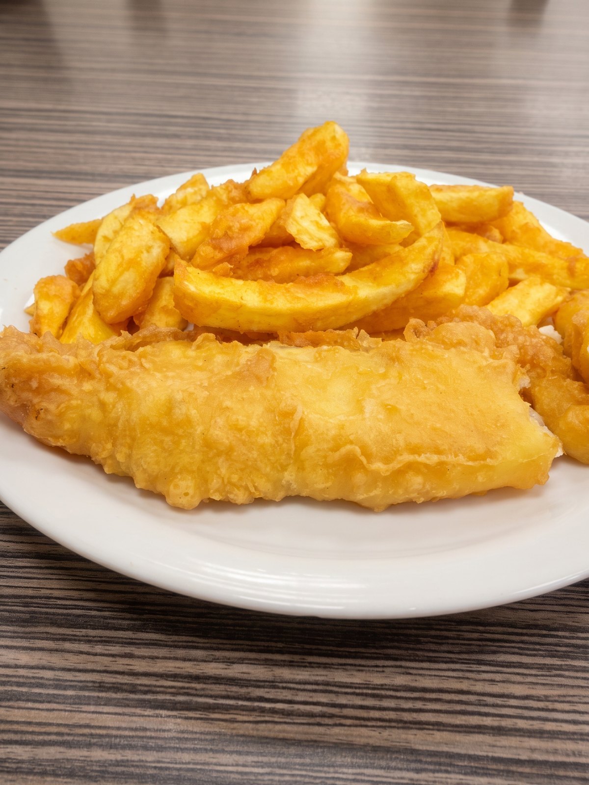 After: studio-lit menu photo of the same fried fish and chips with crisp golden batter and clean presentation