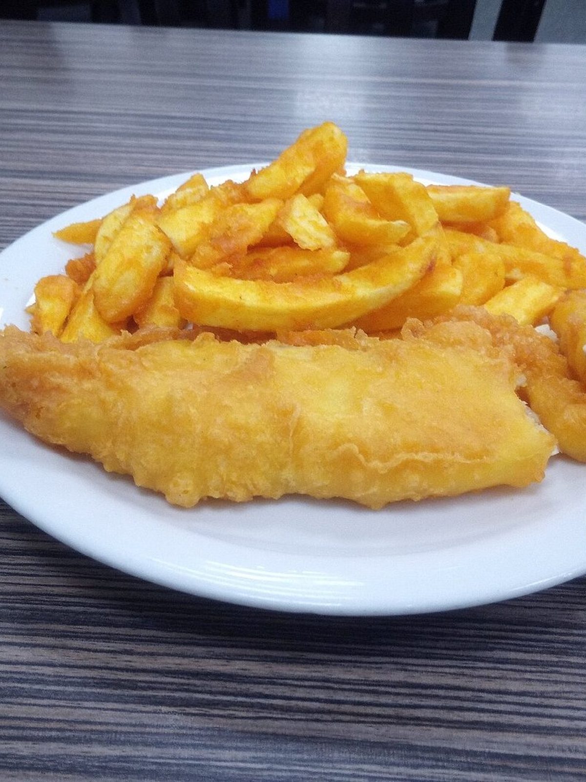 Before: dim phone photo of fried fish and chips on a kitchen counter under flat overhead light