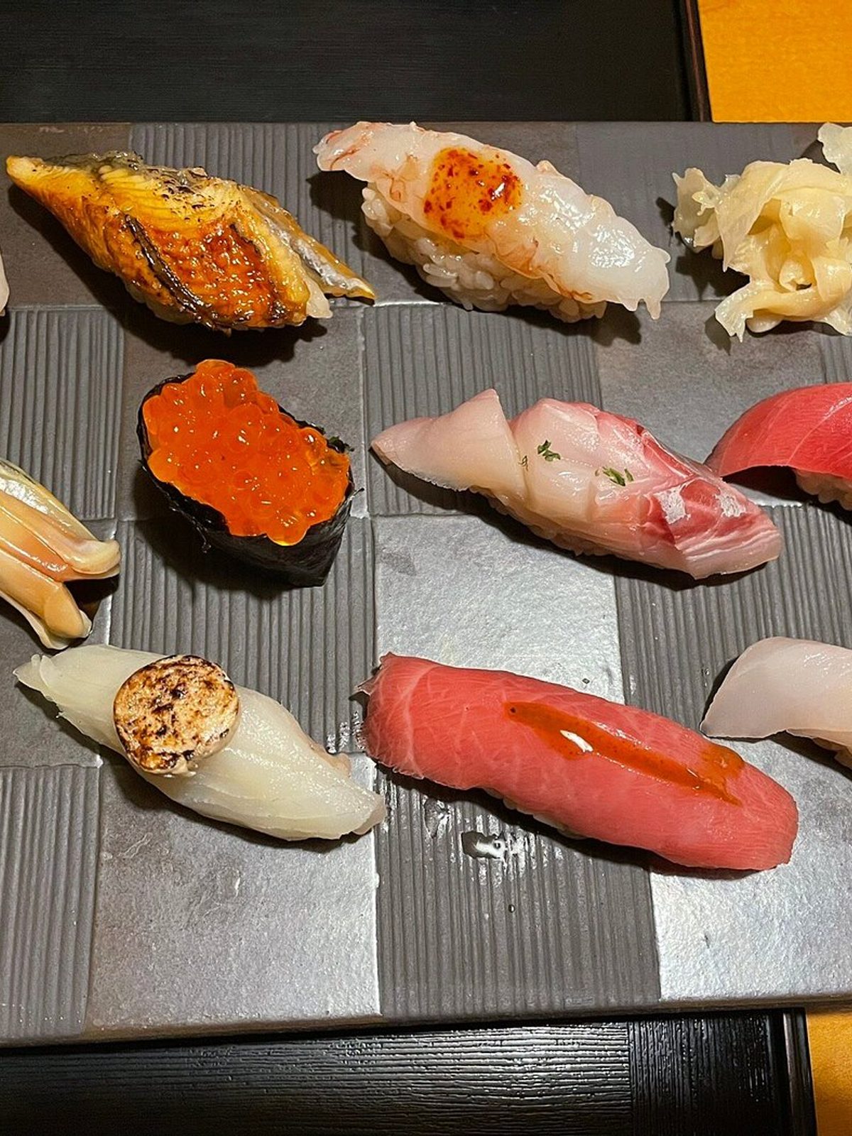 Before: dim phone photo of a plate of nigiri sushi under flat kitchen lighting