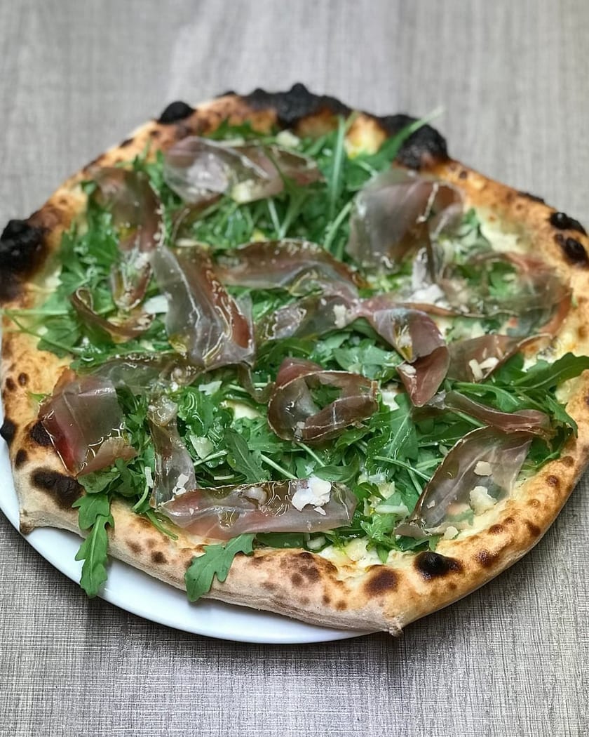 Prosciutto and arugula pizza, relit with PlateRefresh — unedited phone photo