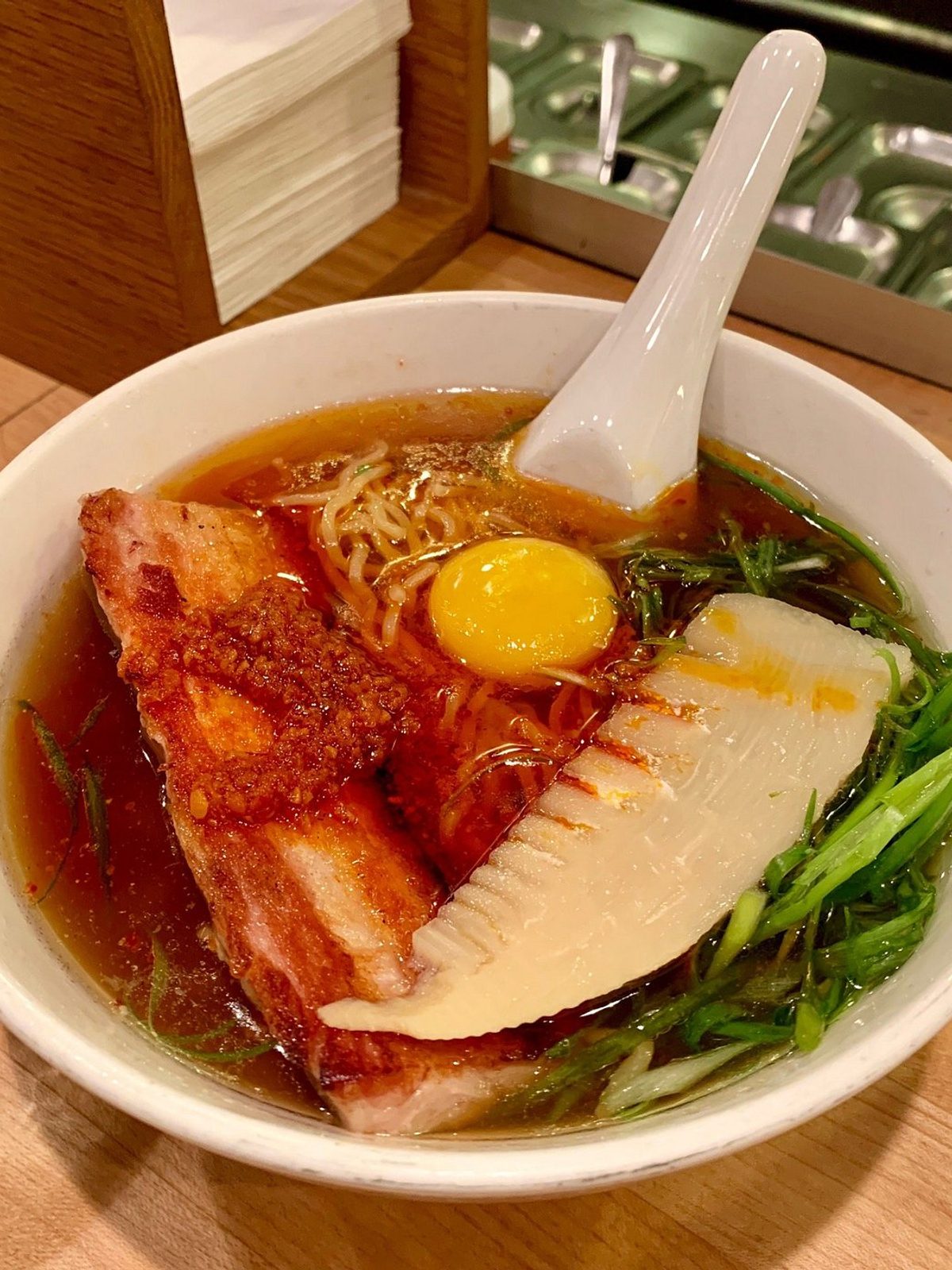 Before: dim phone photo of a bowl of ramen with noodles and toppings on a counter